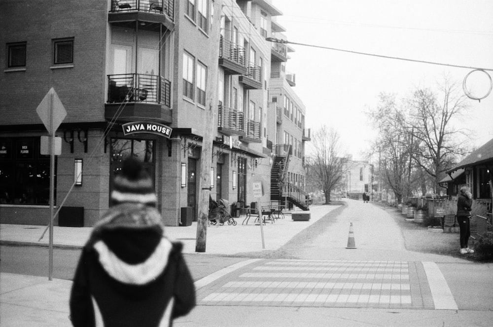 a black and white photo of a person walking down a street