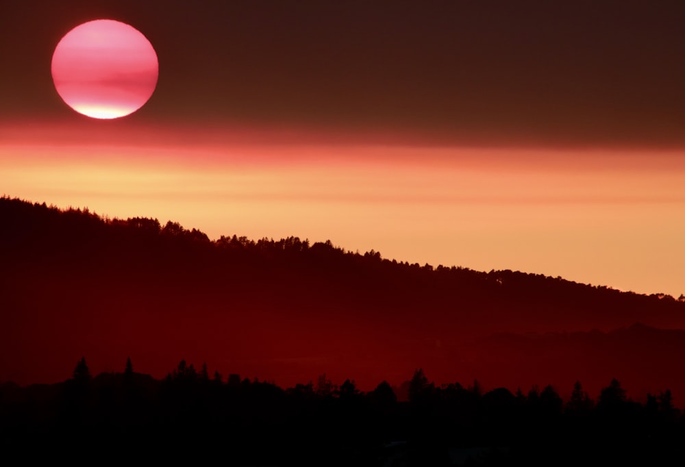 the sun is setting over a mountain range