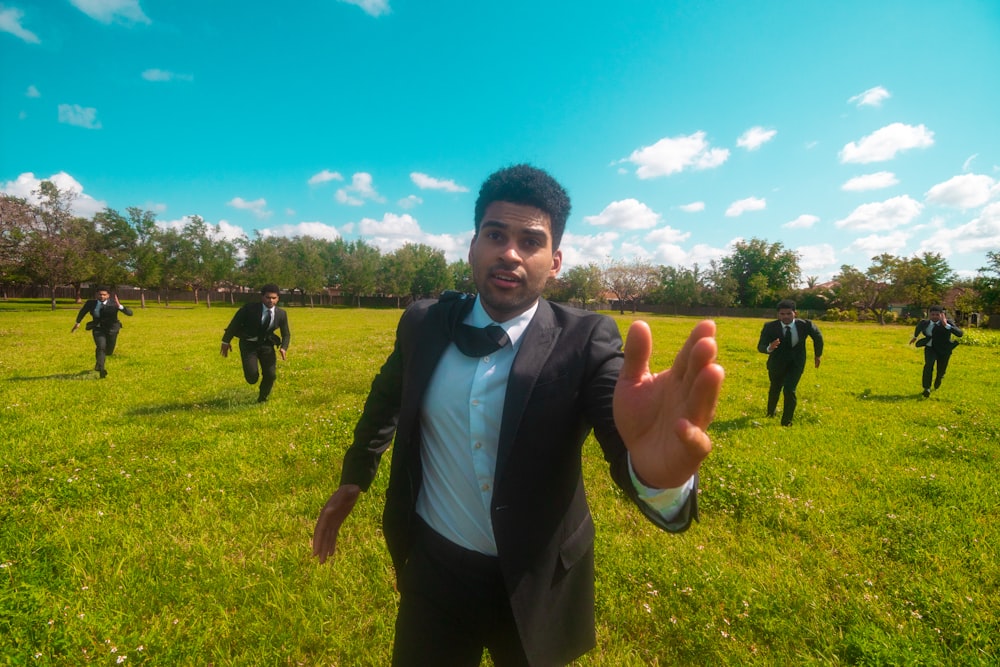 a man in a tuxedo standing in a field