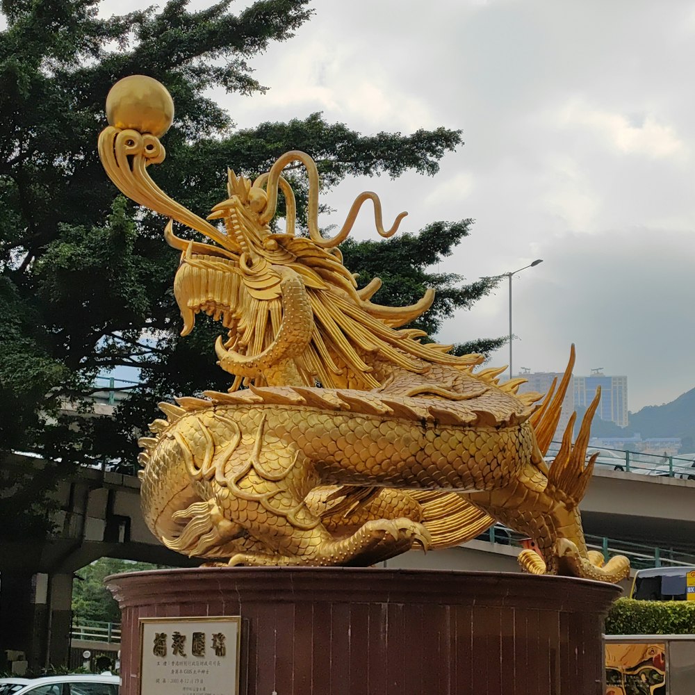 a golden statue of a dragon on a pedestal
