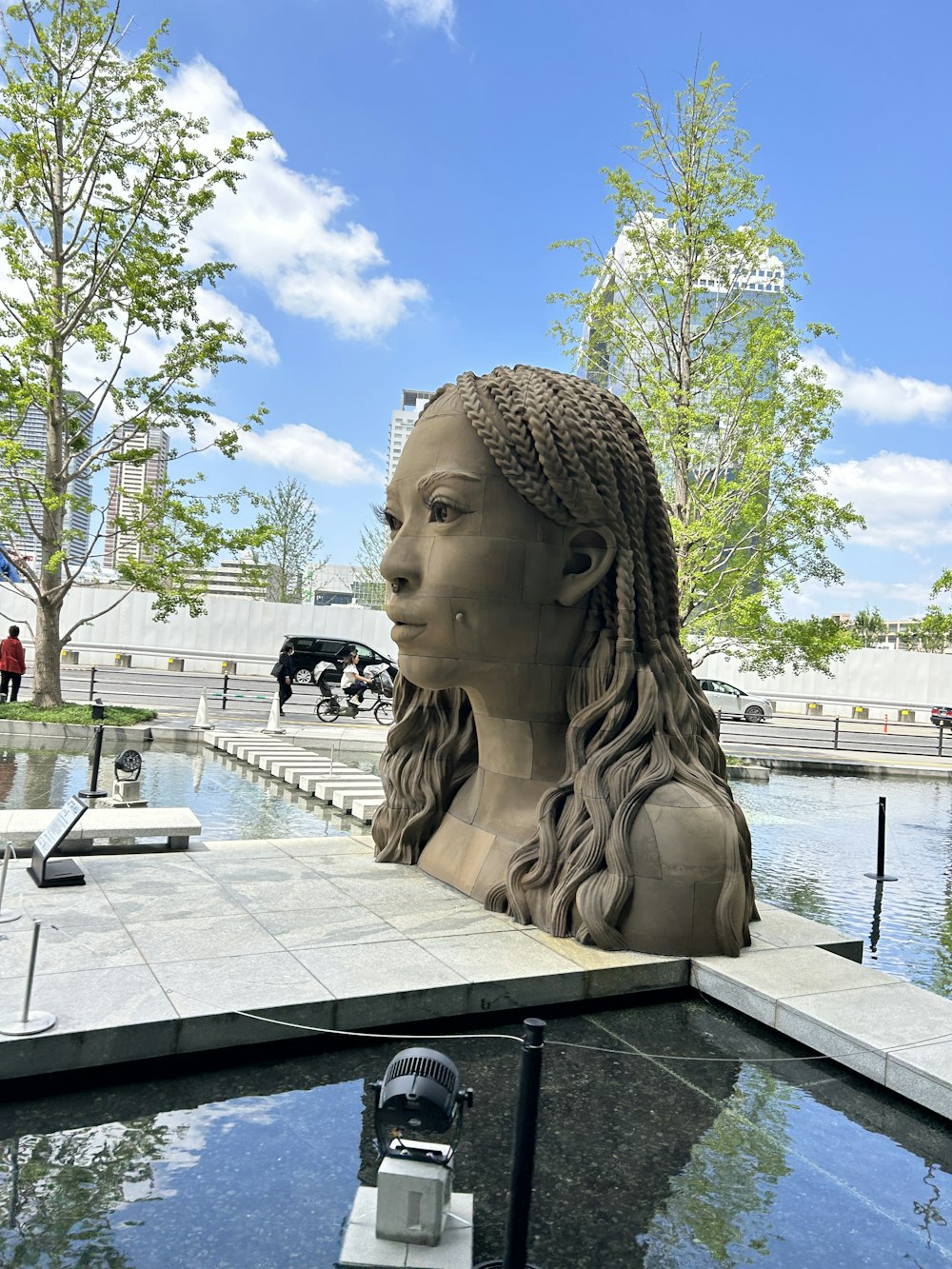 Une statue d’une femme avec des tresses dans un parc