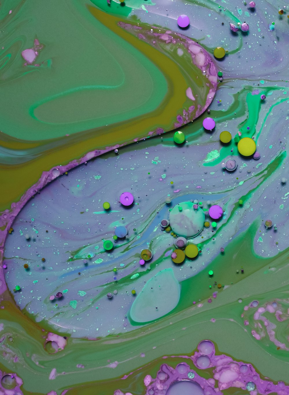 a close up of a painting with green and purple colors