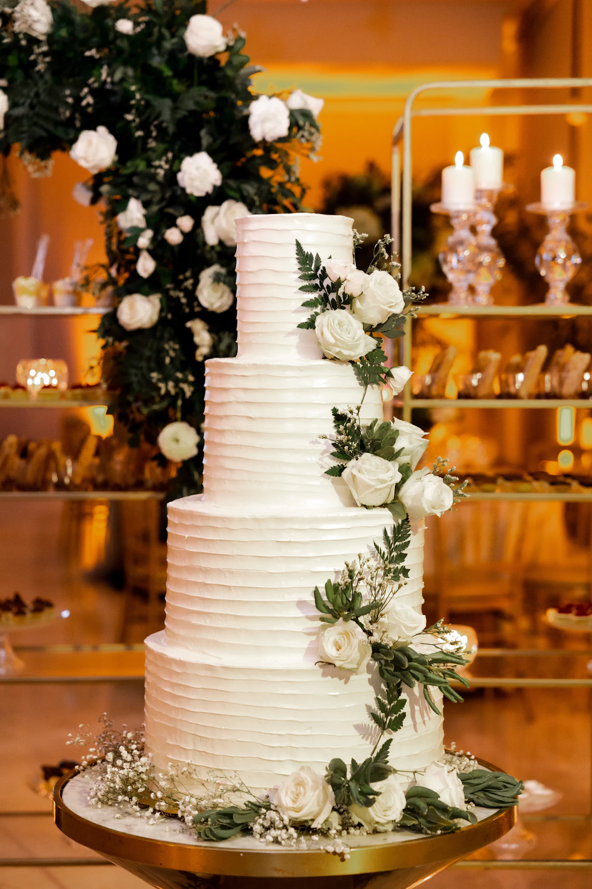 A wedding cake with white flowers and greenery