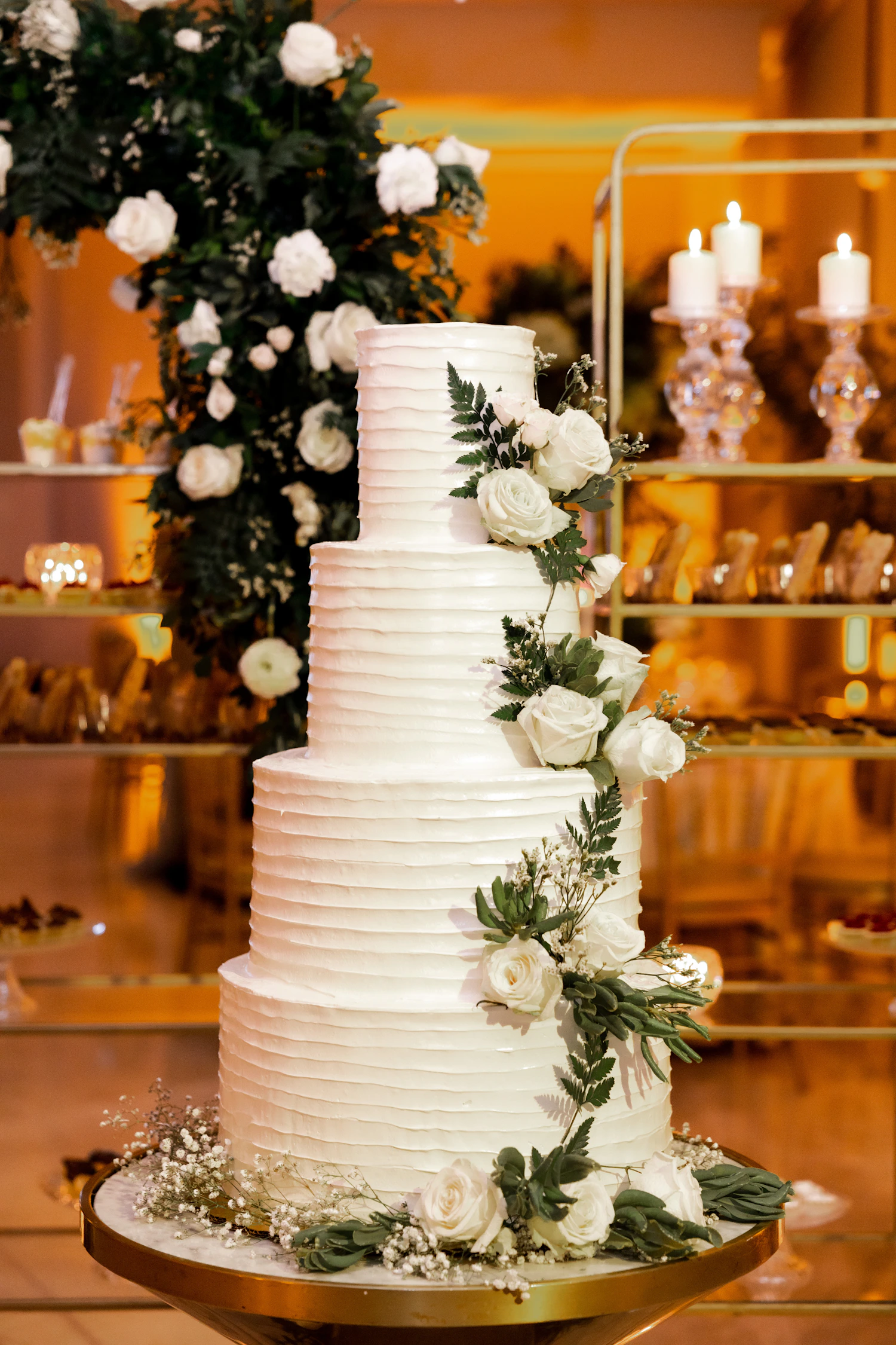 A wedding cake with white flowers and greenery