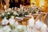 a table set for a formal dinner with candles and flowers