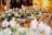 An elegantly set table with white floral arrangements and greenery cascading down the center. The table is adorned with candles and sparkling glassware, creating a warm and inviting atmosphere. The soft lighting enhances the overall sophisticated ambience.