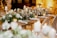 A beautifully arranged corporate event space with elegant table settings and floral decorations.