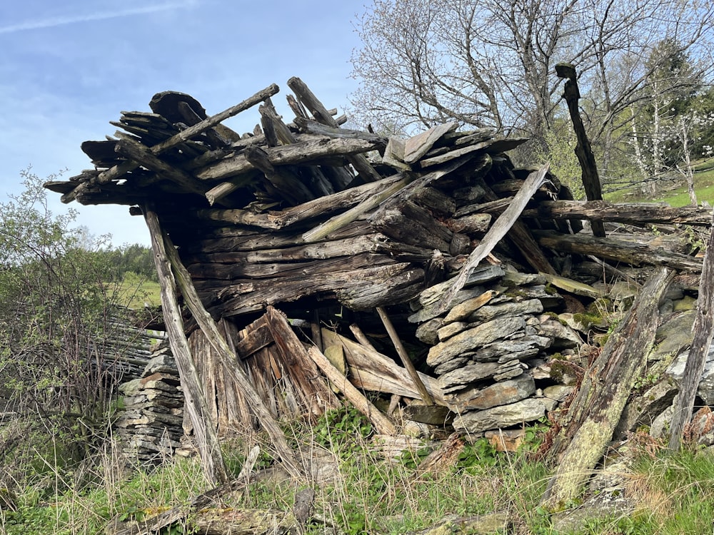 a pile of wood sitting on top of a lush green field