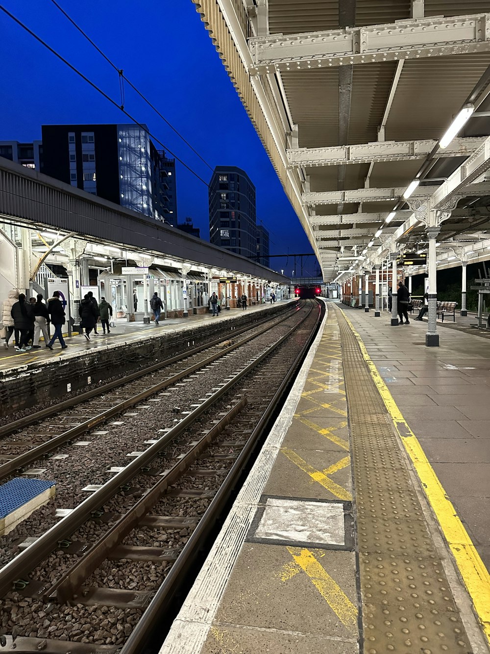 a train station with people waiting for the train