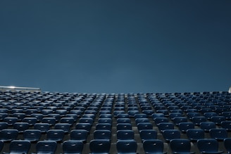 a stadium filled with blue seats under a blue sky