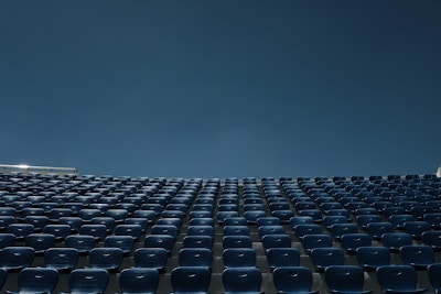 a stadium filled with blue seats under a blue sky