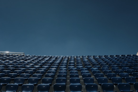 a stadium filled with blue seats under a blue sky