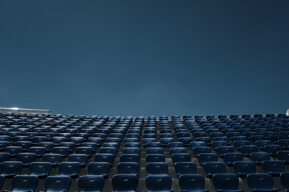 a stadium filled with blue seats under a blue sky