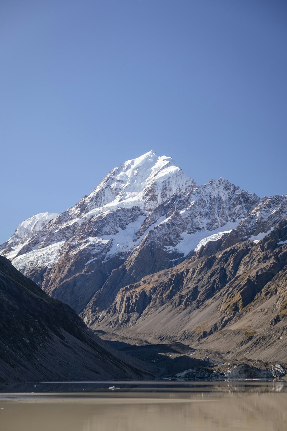 a mountain range with a lake in the foreground