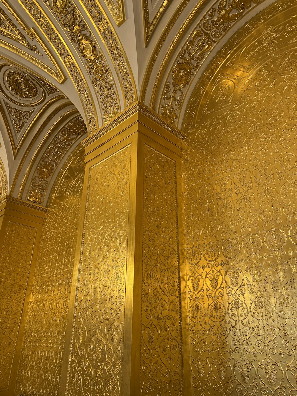 a golden wall in a building with a clock on it