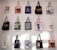 A collection of tote bags, each with a unique design, hangs on a white wall. The designs include art prints, graphic texts, and images of people. The bags are arranged in a grid with varied colors and artistic themes.
