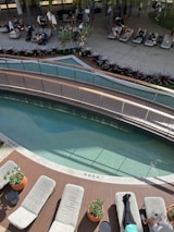 Guests chatting and relaxing in the shaded outdoor area of Clube Aqua during daylight hours.