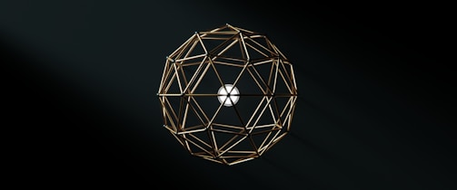 A geometric structure composed of interconnected golden rods forms a spherical shape against a dark background, with a white circular center providing contrast.