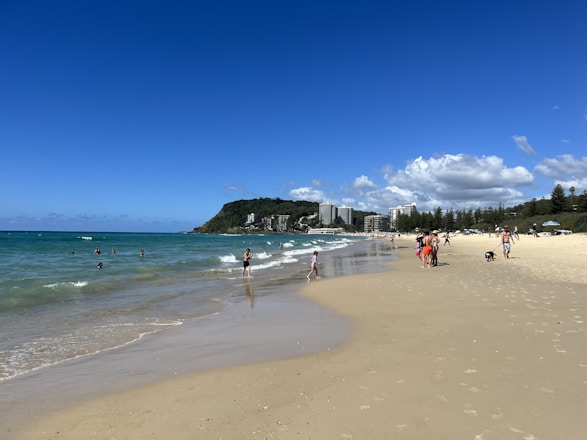 A sunny beach in São Paulo with clear blue water and people enjoying the shore.