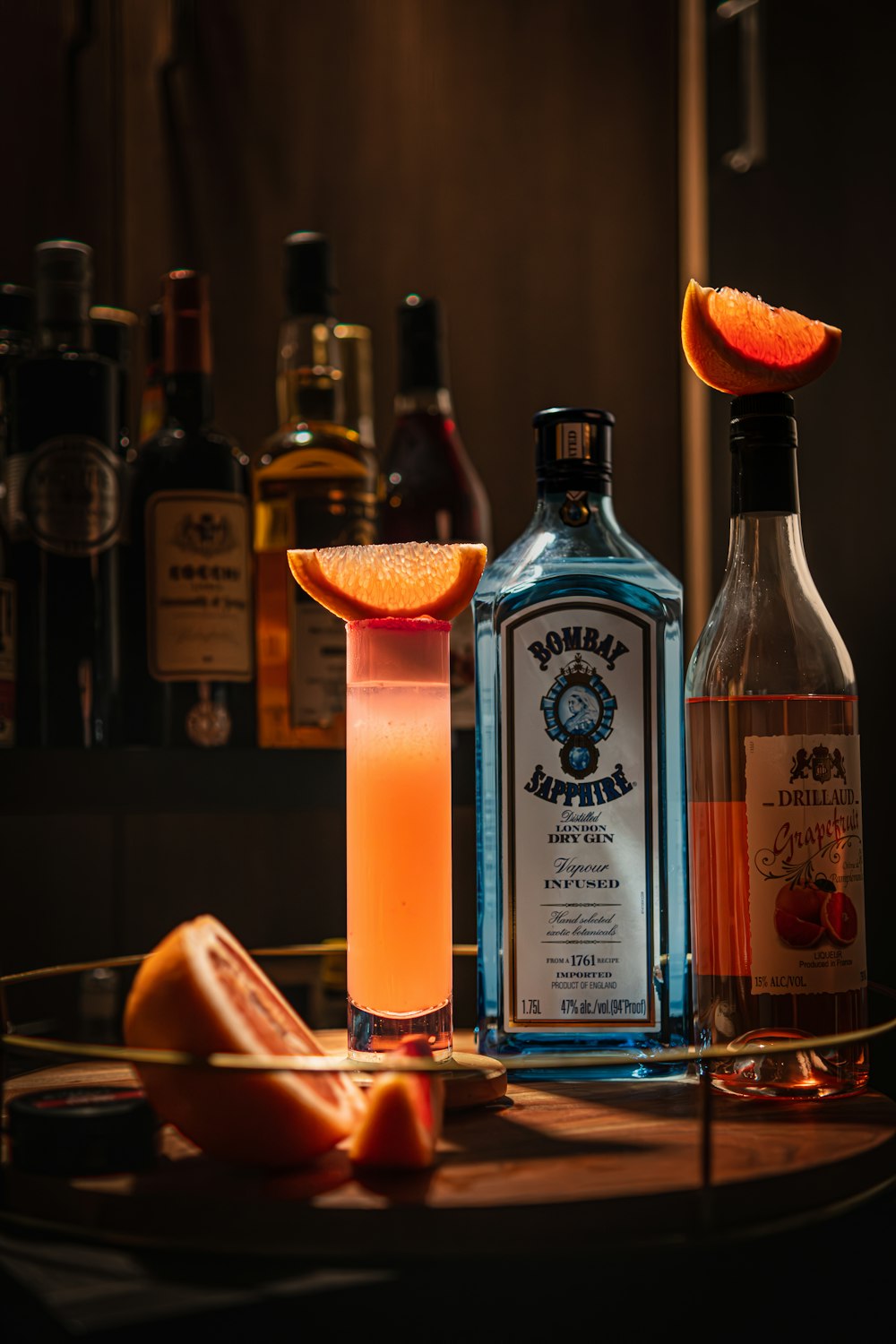 a table topped with bottles of alcohol and orange slices