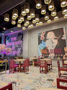 A warm, inviting restaurant interior with Asian-inspired decor and a beautifully plated fusion dish on the table.