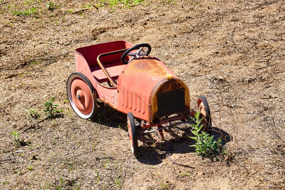an old fashioned red cart with a plant growing out of it