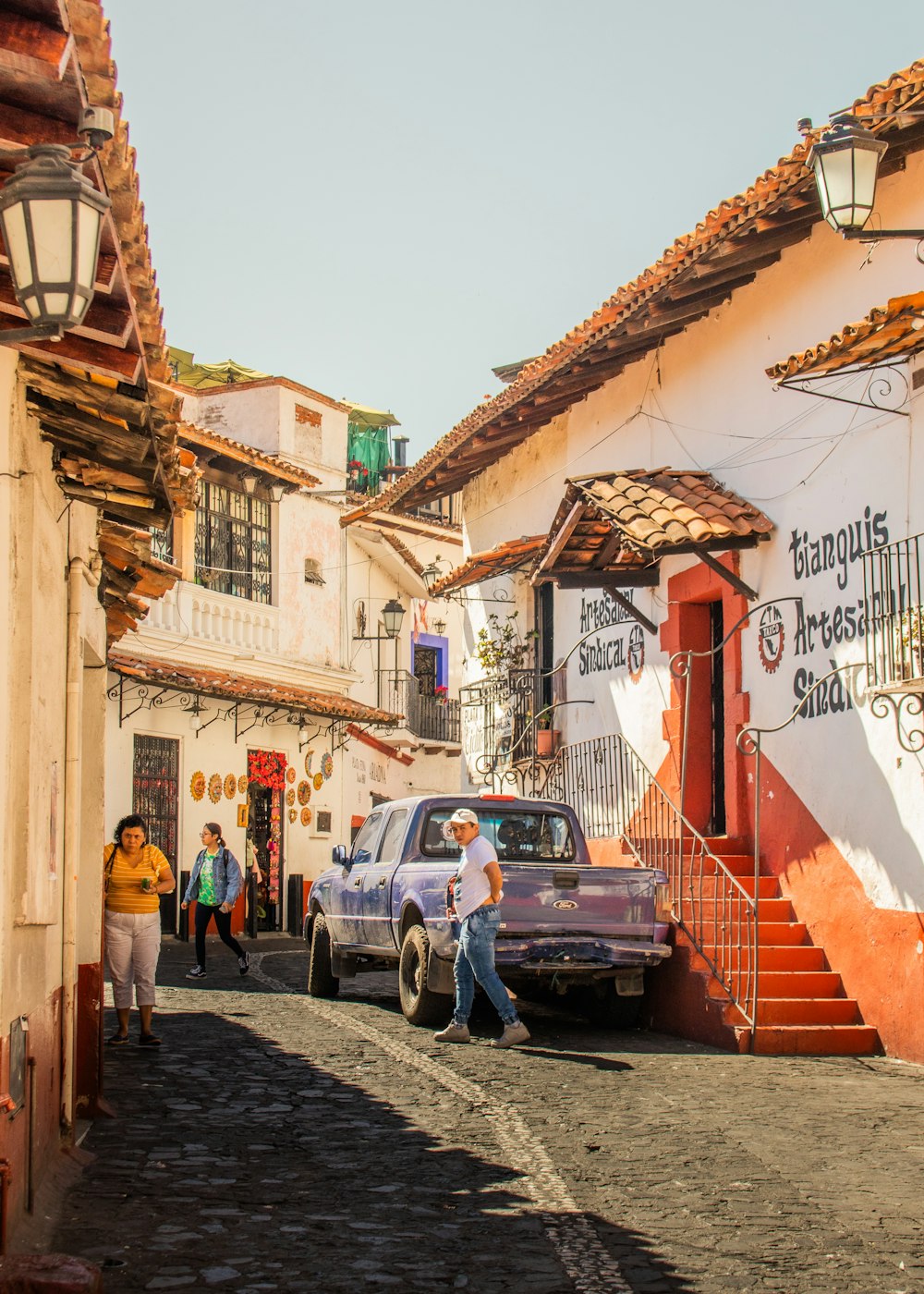 a man is walking down a cobblestone street