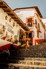 Street view of a colorful Tarija hostel with guests sitting outside.