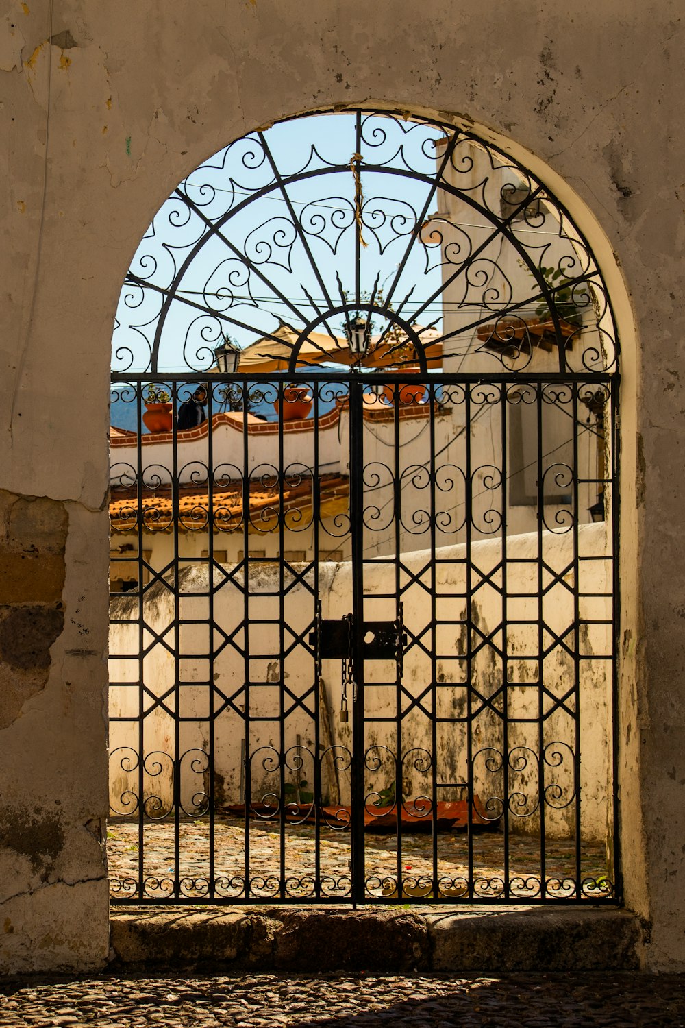 an iron gate with a building in the background