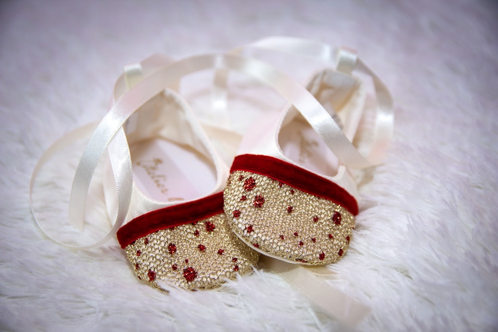 a pair of red and white shoes on a white fur surface