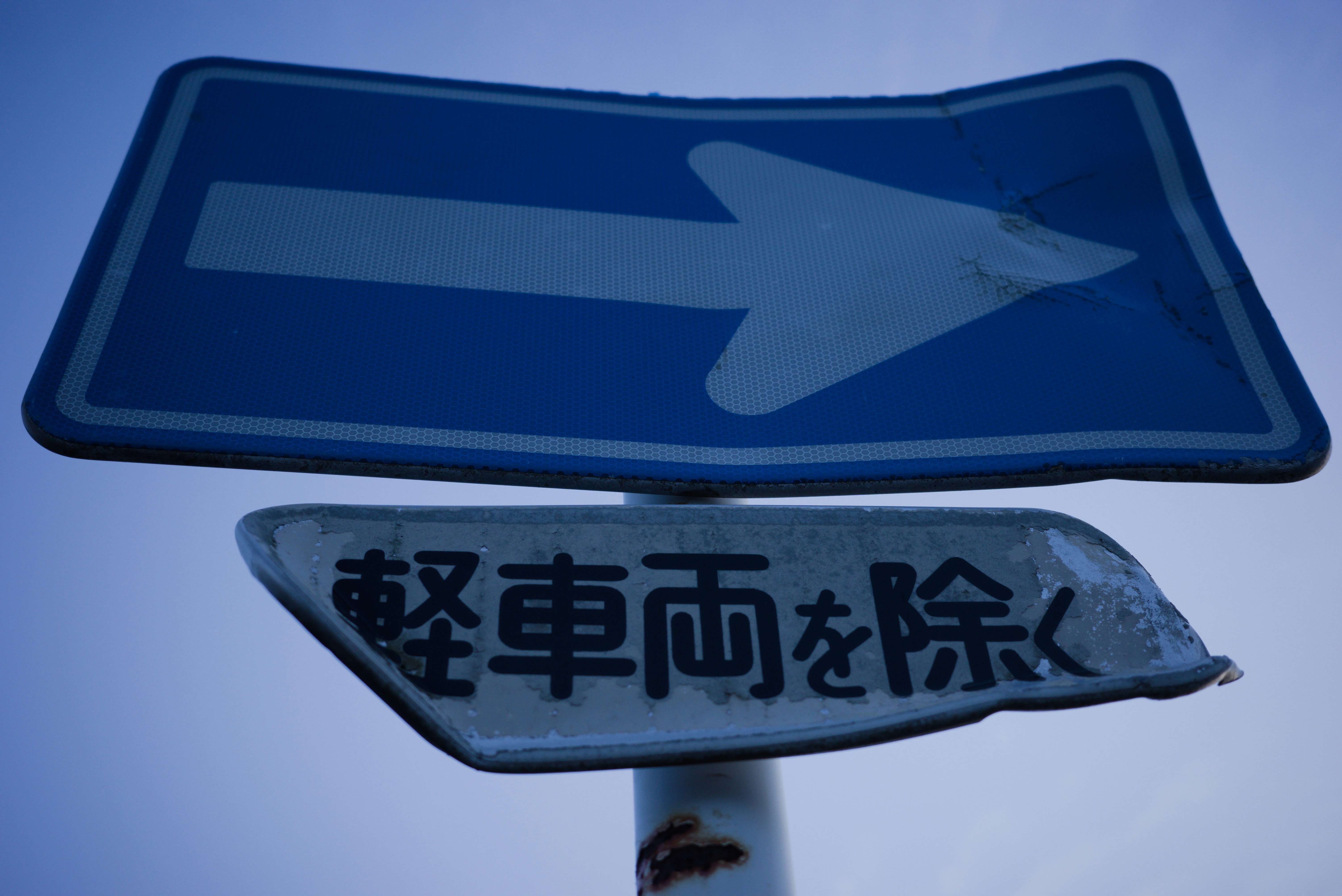 a blue street sign with a white arrow on it