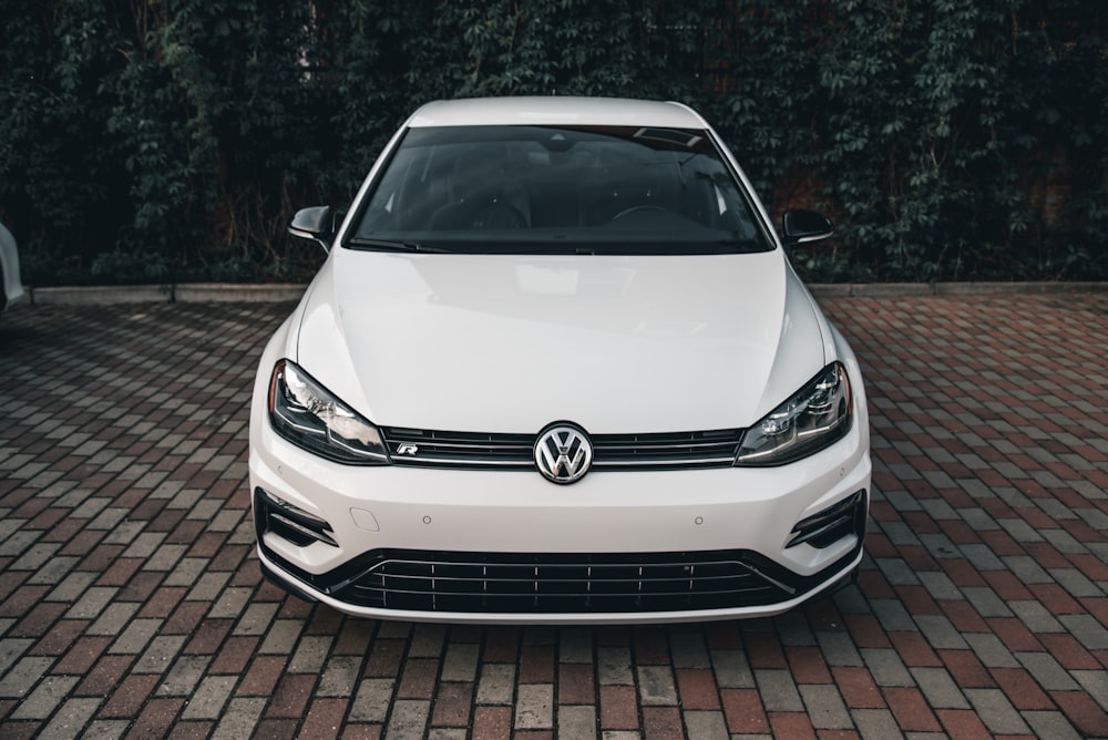 a white car parked on a brick road