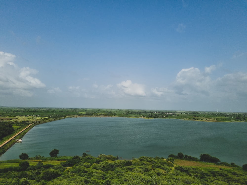 a large body of water surrounded by lush green trees