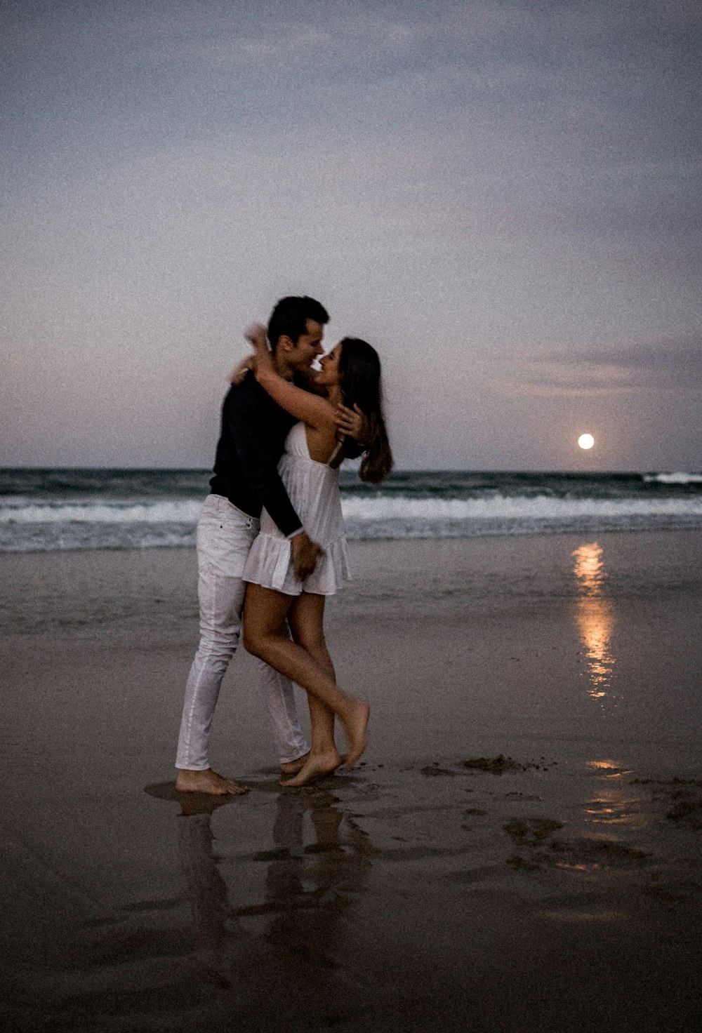 um homem e uma mulher se abraçando na praia