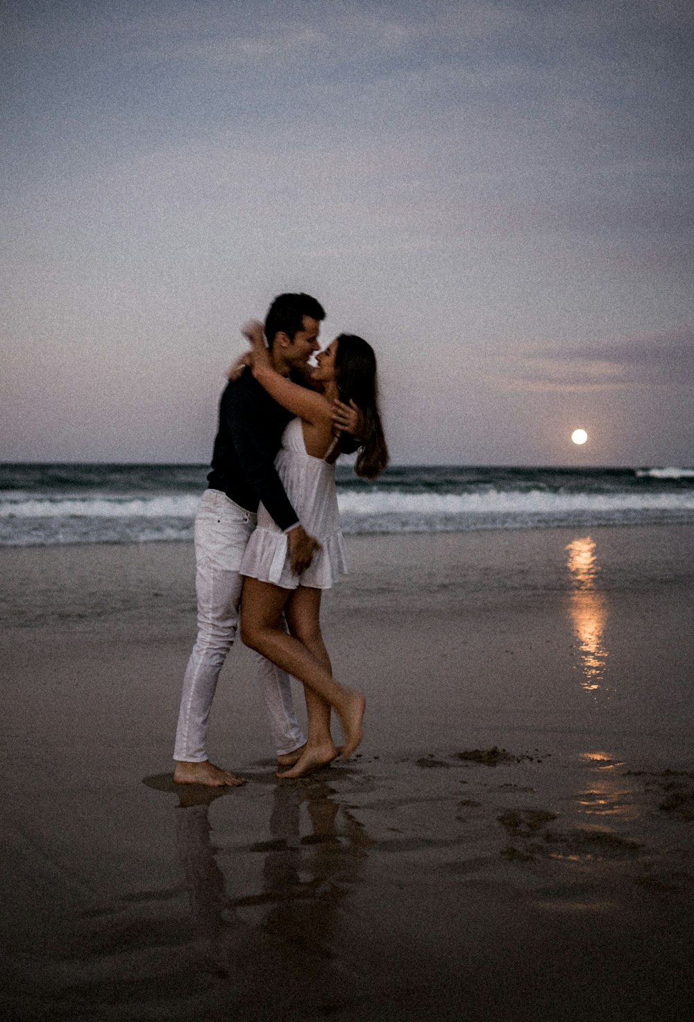 a man and a woman hugging on the beach