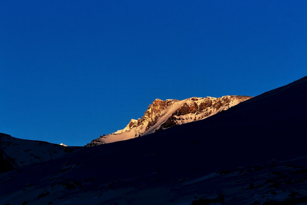 a snow covered mountain under a blue sky