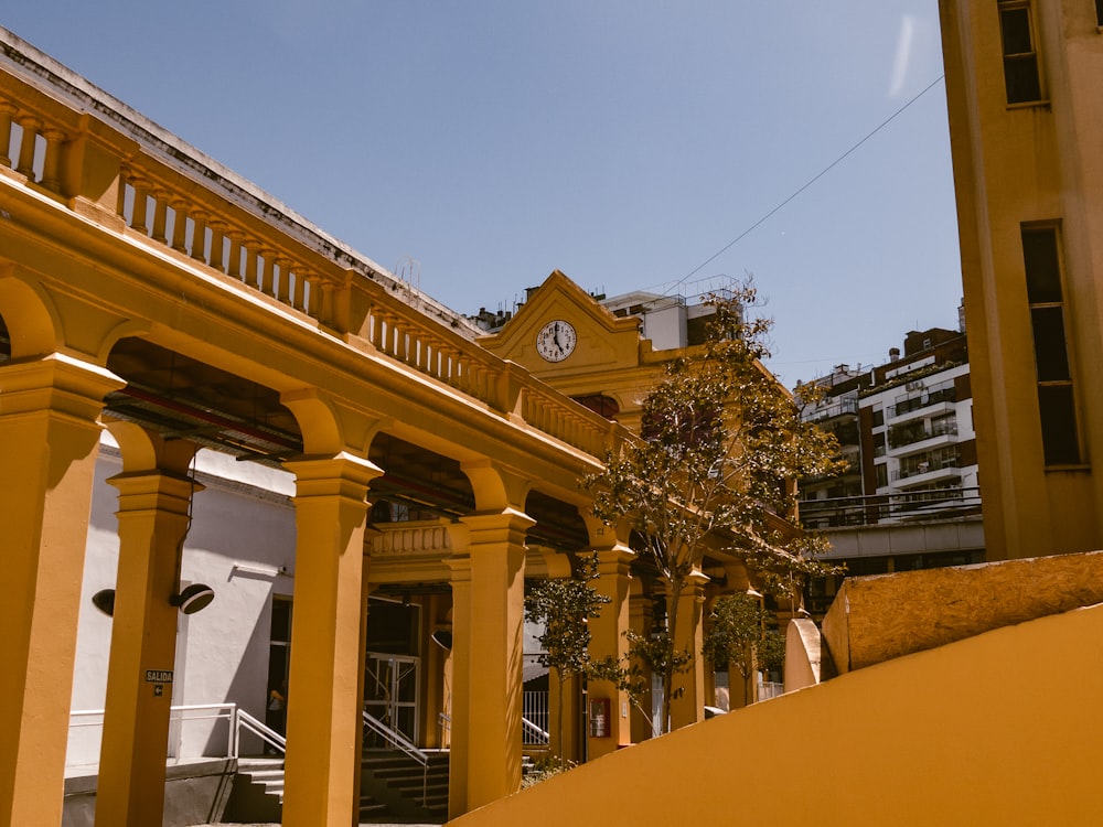 a yellow building with a clock on the front of it