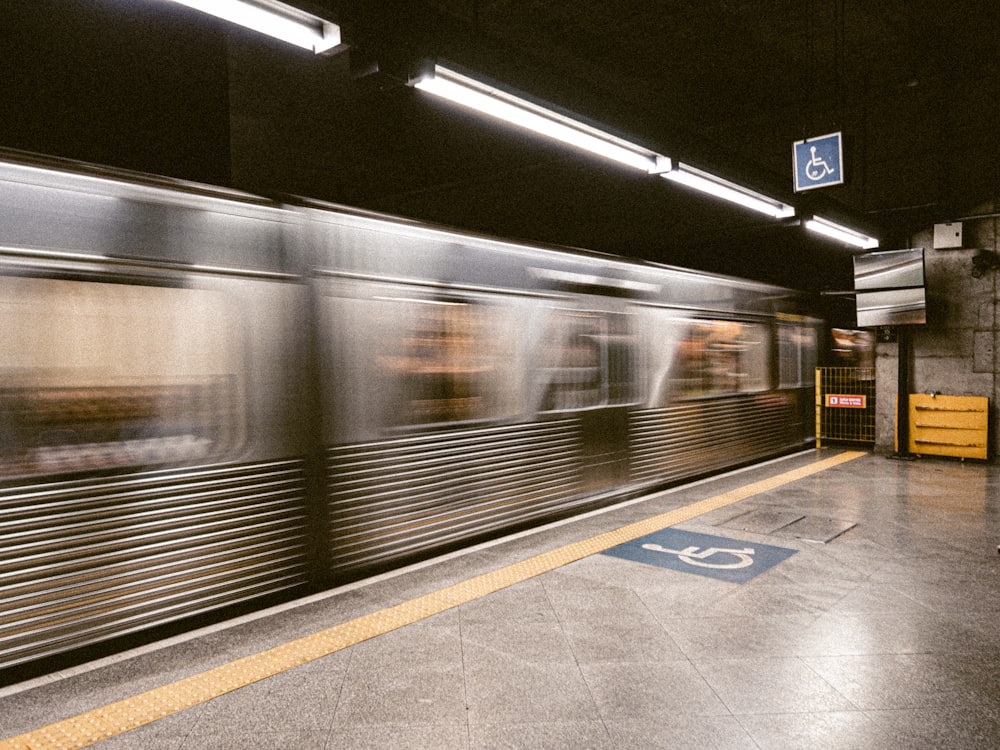 a subway station with a train speeding by