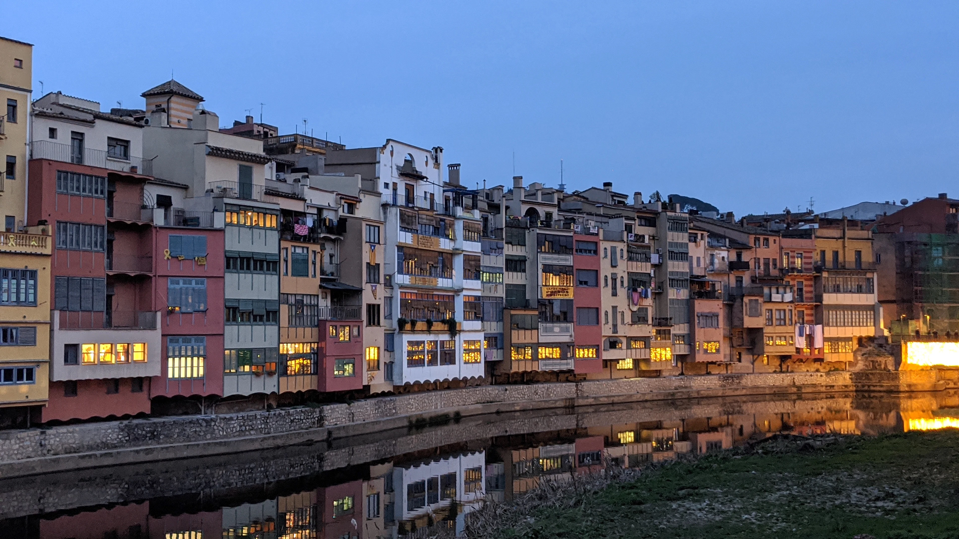 Girona's coloured houses along the river Onyar at dusk, reflected in the water