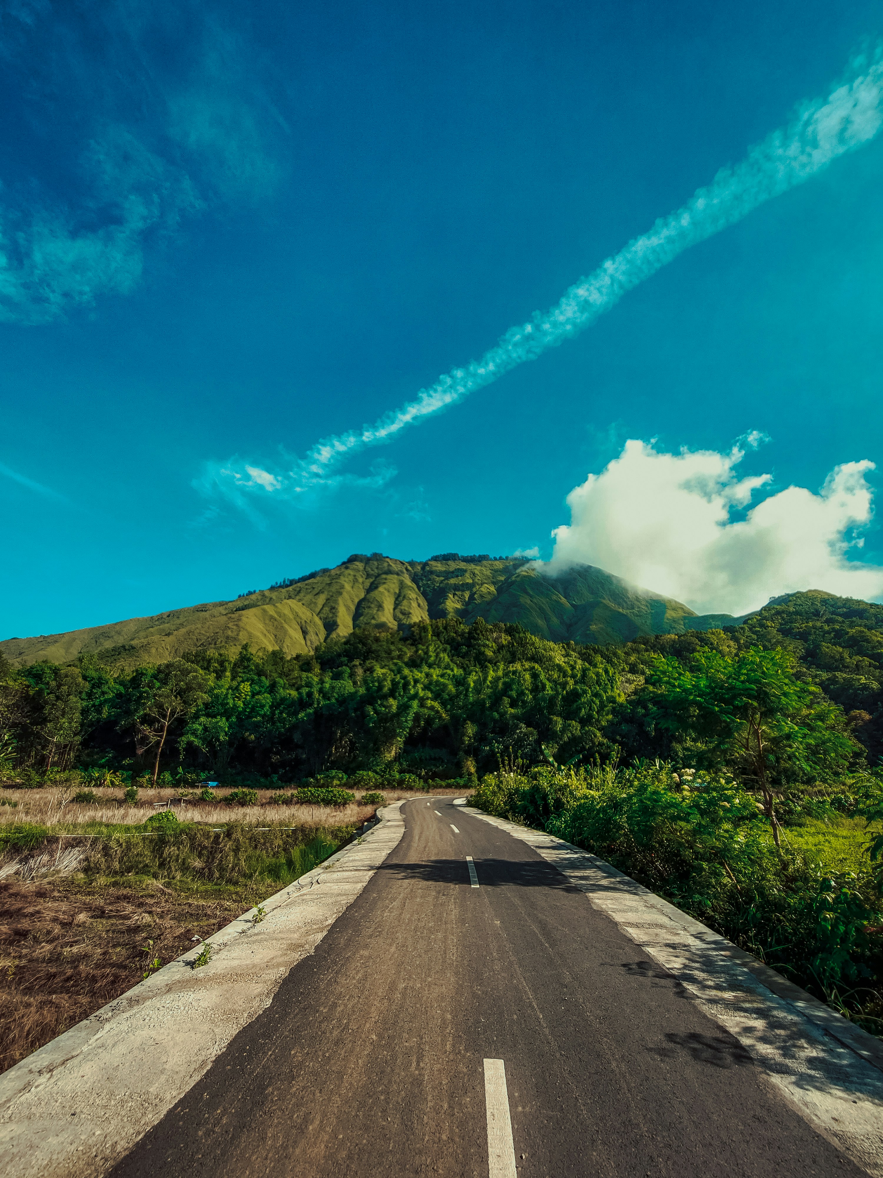 an empty road with a mountain in the background