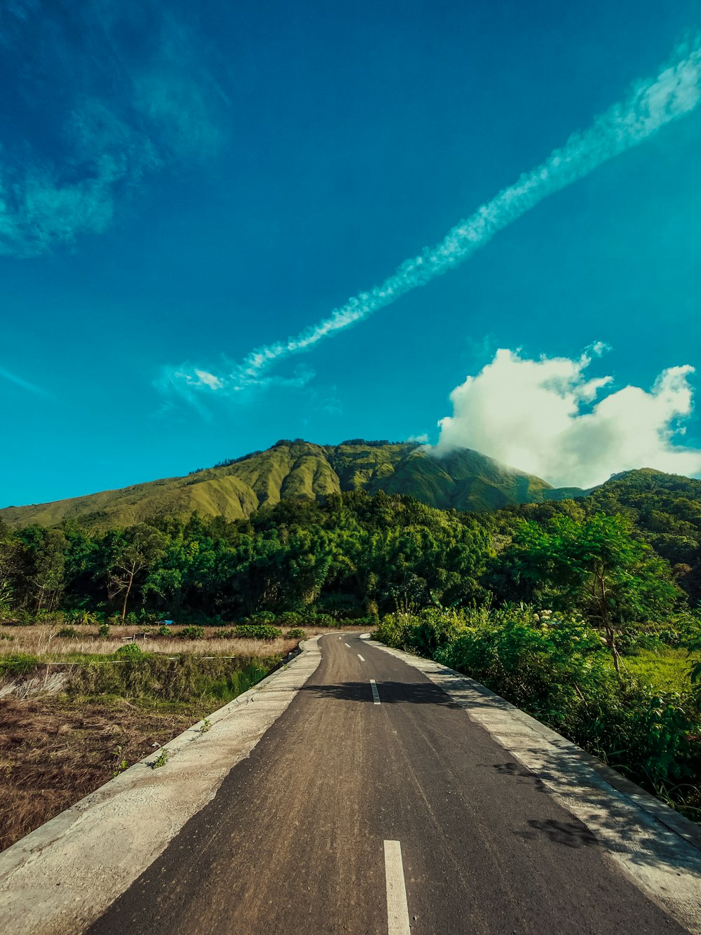 an empty road with a mountain in the background