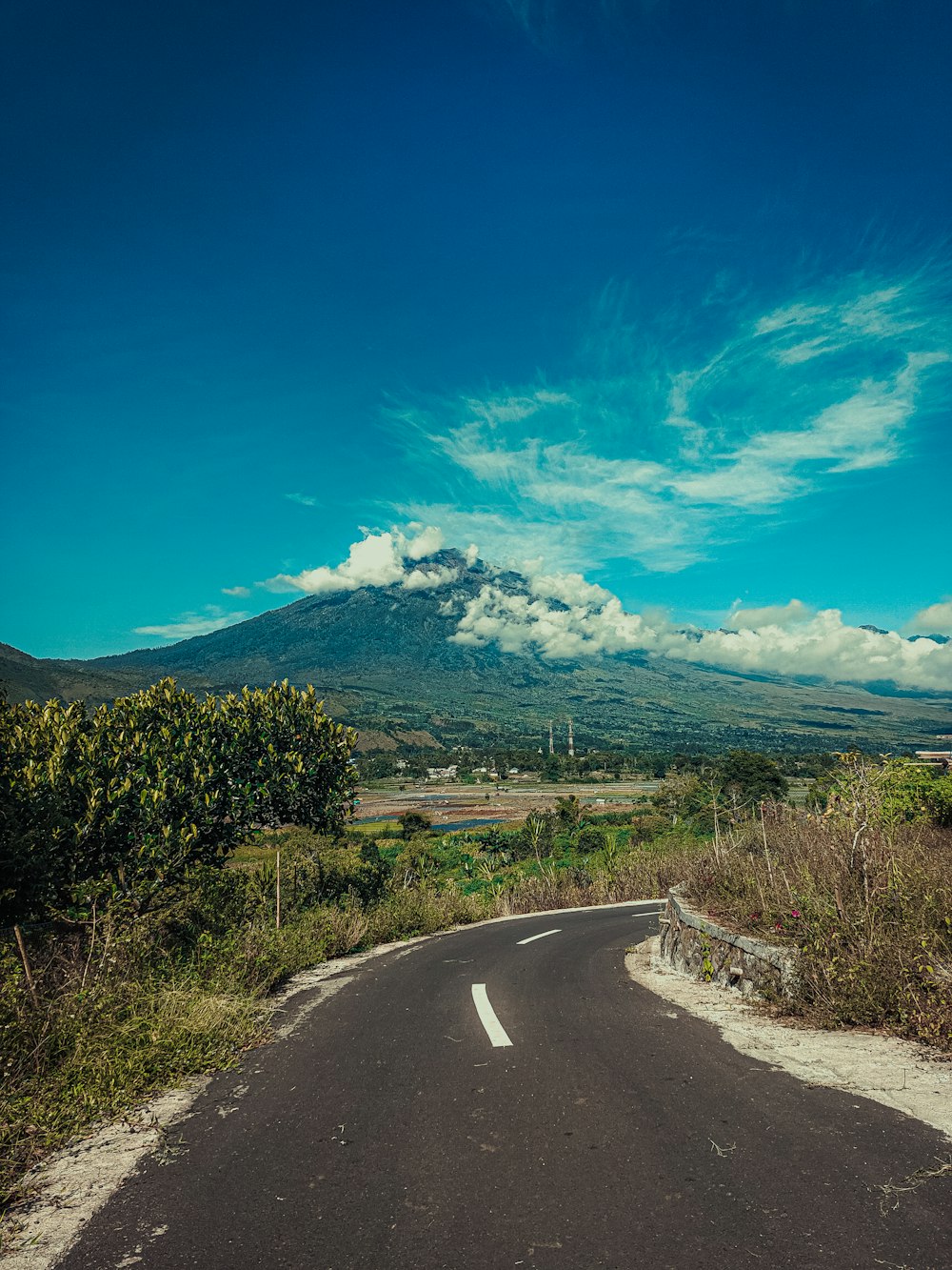 an empty road with a mountain in the background