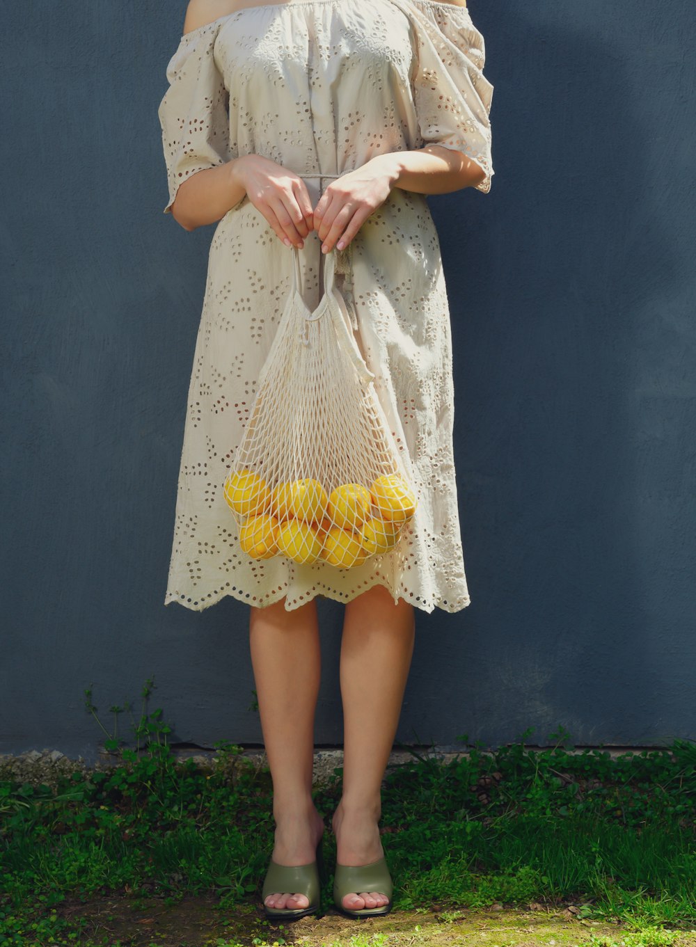 a woman in a white dress holding a yellow purse