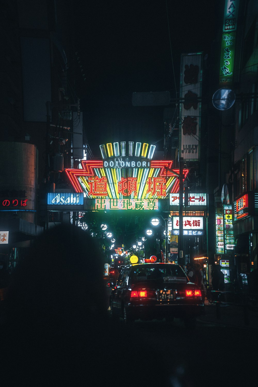 Uma rua movimentada da cidade à noite com placas de neon