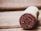 A close-up of a wine cork with the year 2017 imprinted on the end. The cork lies on a wooden surface, suggesting a rustic or vintage setting.