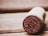 A close-up of a wine cork with the year 2017 imprinted on the end. The cork lies on a wooden surface, suggesting a rustic or vintage setting.