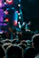 A lively concert crowd with a close-up of a person enjoying music wearing sleek earplugs.