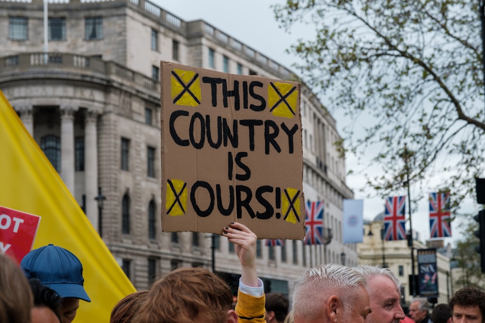 a group of people holding a sign that says this country is yours