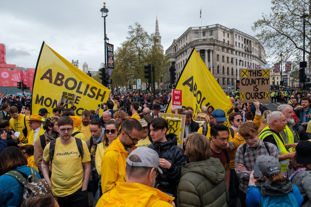 a large group of people holding yellow signs