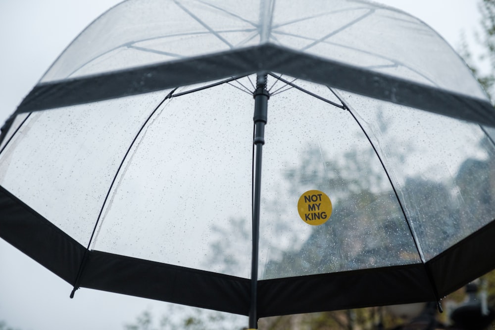 a clear umbrella with a yellow sticker on it